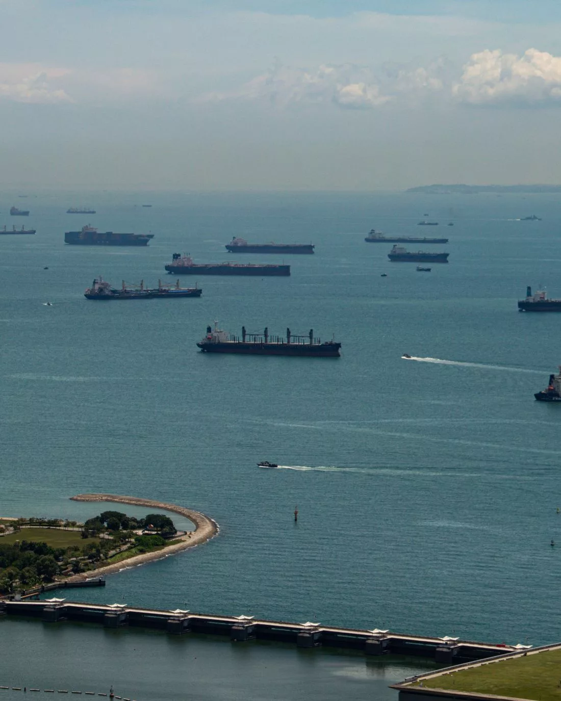 Ships lying at anchor in an open anchorage under a clear sky