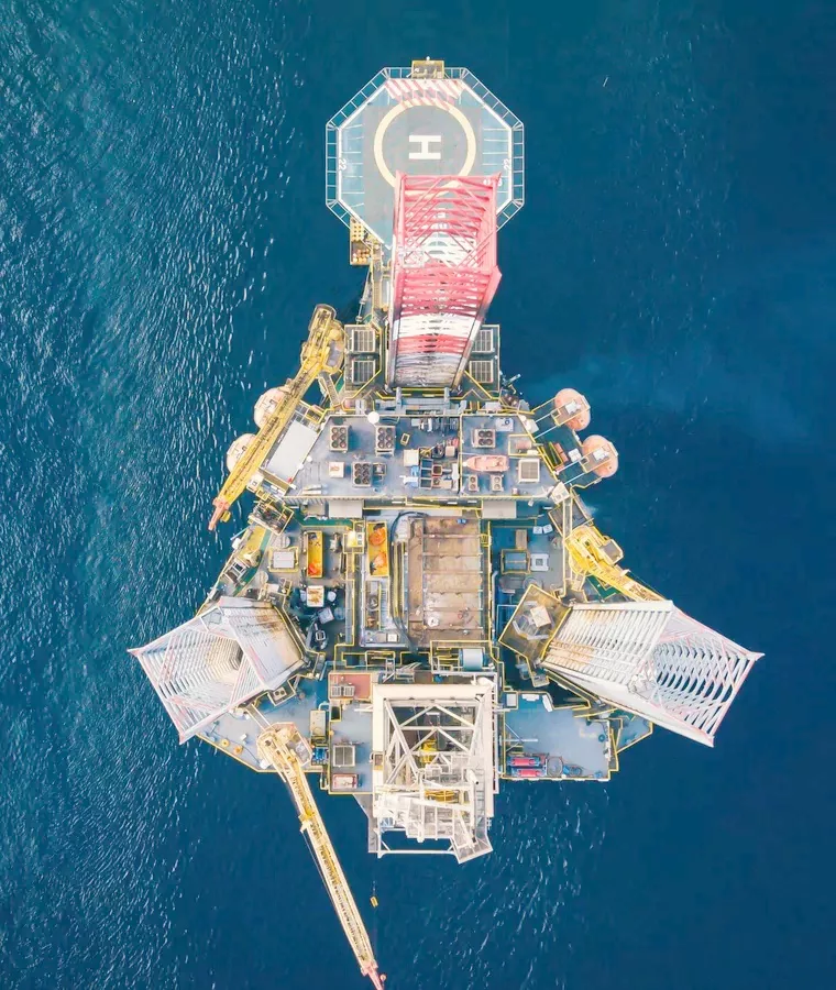 Offshore platform seen from directly above with its helideck and cranes