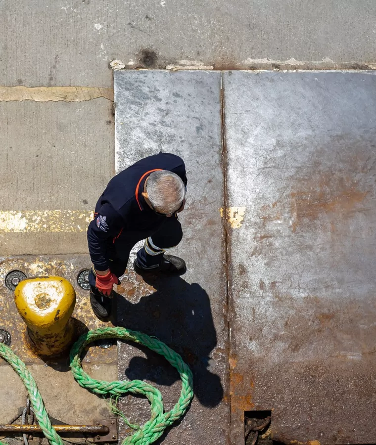 Linesman handling a mooring line at a set of quayside bollards