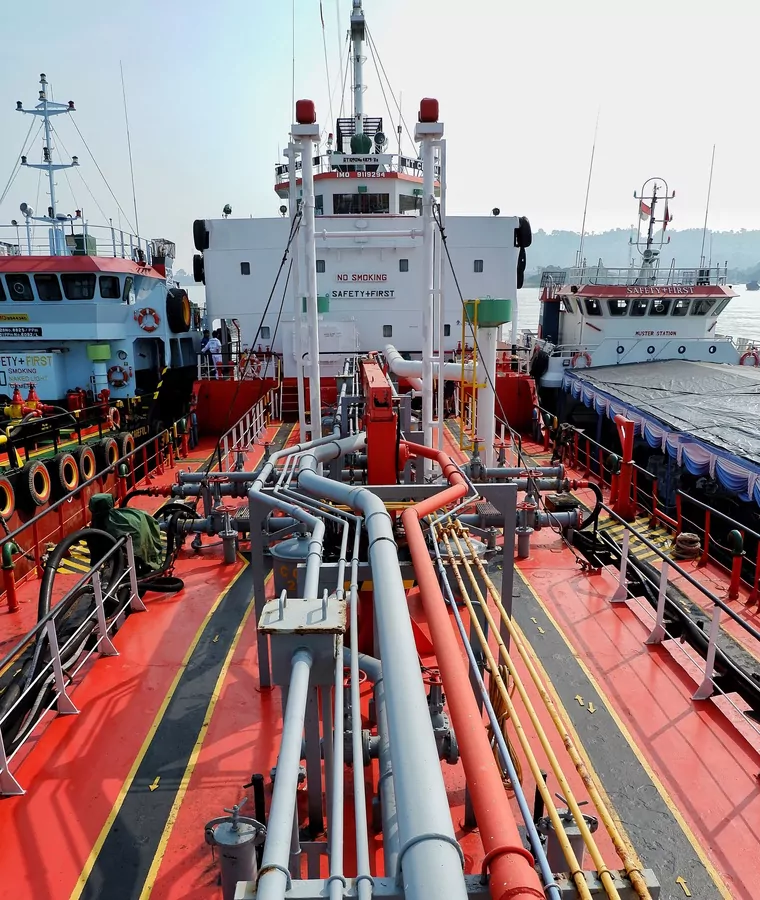Tanker main deck with a bunker barge and support craft made fast alongside