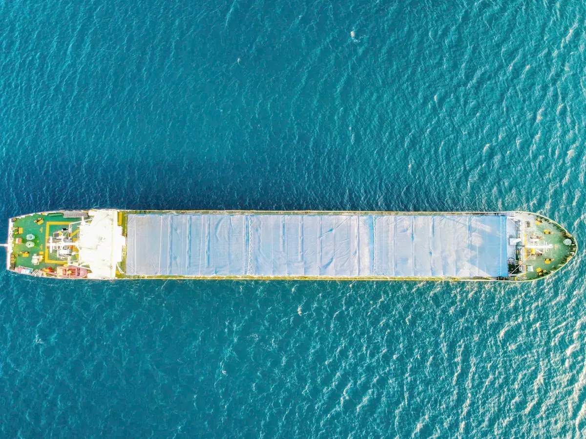 Cargo vessel seen from directly above with its hatches covered