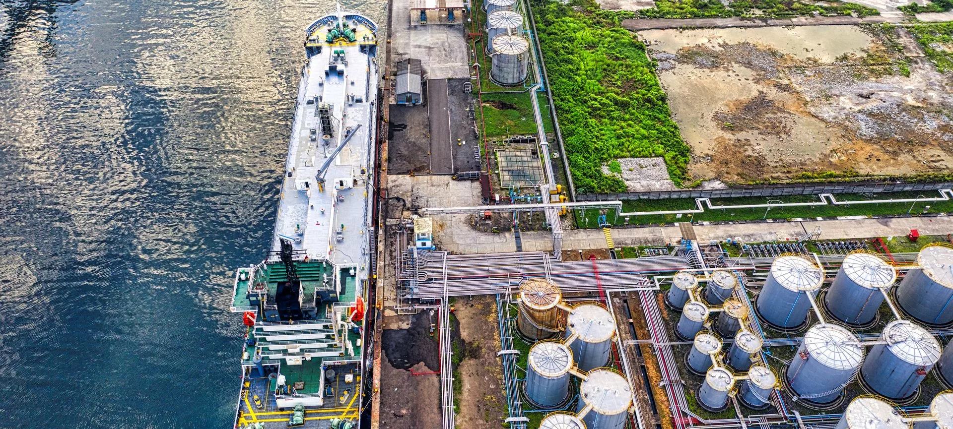 Aerial view of a vessel alongside a coastal tank farm